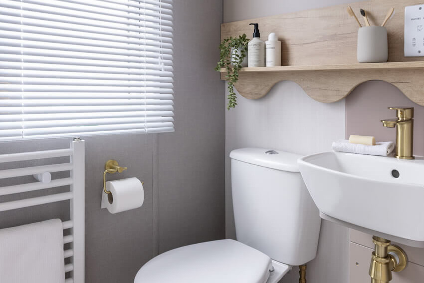 Modern bathroom with brass finishes with window in the Burgundy caravan